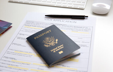 American passport with visa application documents on white table