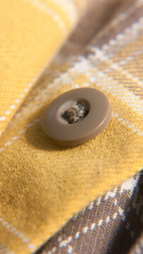 Bot&oacute;n en camisa a cuadros amarillo