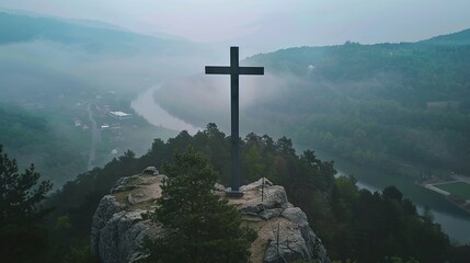 a large wooden cross sits at the top of the mountain