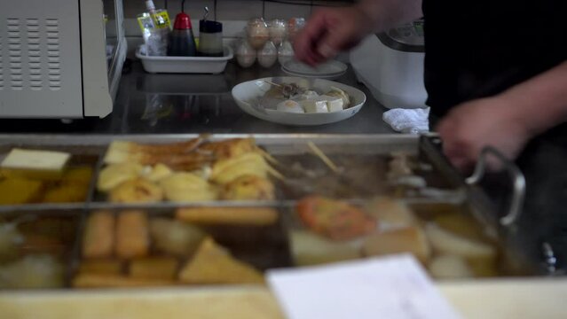 Japanese chef preparing warm autumn boild dish oden boil fish cakes chef cutting tofu and ingredients for serving