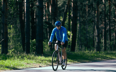 Fototapeta na wymiar Cyclist rides through the park on a summer day.