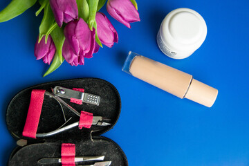 Tools and cosmetics needed for nail styling on a blue background. Pedicure set isolated on white....