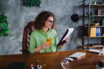Photo of nice lovely glad woman reading paper list cv resume in modern office room workspace...