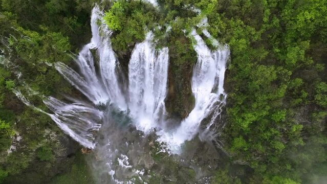 Amazing aerial video of Plitvice national park with lakes and picturesque waterfalls in a green spring forest, Croatia. Drone flight around The Great waterfall.