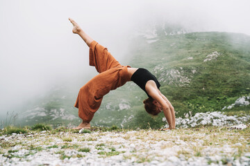Yoga on nature. Young woman is practicing yoga in mountains - 789344793