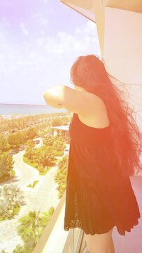 Girl Stands on the Balcony of the Apartment and Looks at the Sea. Female Admire Beautiful Ocean View. Relax, Beauty, Summer Vacation. High quality 4k footage