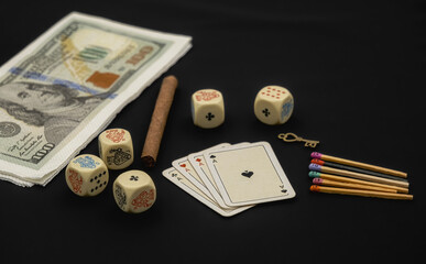 Gambling concept with cards, cigarettes, poker dice and matchsticks with faces painted on the heads on black background