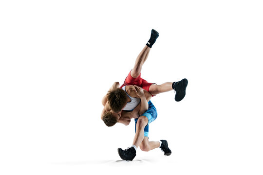 Male wrestlers compete in intense poses, displaying athletic skills, training isolated on white background. Concept of combat sport, martial arts, competition, tournament, athleticism