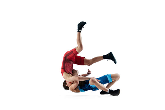 Young men, athletes engaged in challenging wrestling match, demonstrating resilience and skills isolated on white background. Combat sport, martial arts, competition, tournament, athleticism concept
