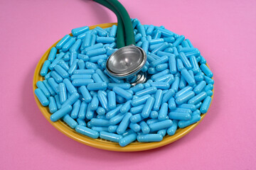 plate with medicine capsules and stethoscope