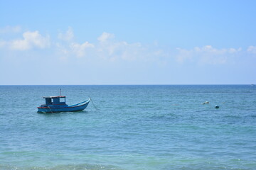 A lonely boat on the sea, blue sky. Blue sea, summer, vacation and travel