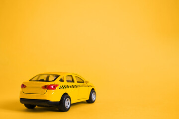 Urban taxi and delivery service concept. Toy yellow taxi car model. Copy space for text, banner....
