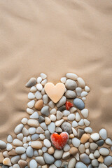Fototapeta na wymiar Heart-shaped pebbles arranged on a sandy beach, with waves in the background сreated with Generative Ai