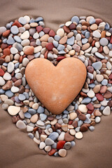 Obraz premium Heart-shaped pebbles arranged on a sandy beach, with waves in the background сreated with Generative Ai