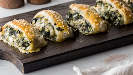 Spinach and feta pastries on a wooden board, hot out of the oven.