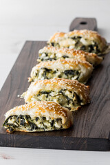Spinach and feta pastries on a wooden board, ready for serving.