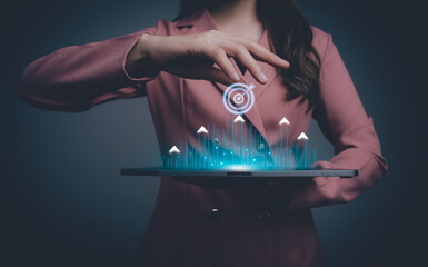 Business goal and target success concept. Businesswoman touching a virtual screen with a target icon and arrows pointing up. Global economic trend analysis, Financial graph analysis.
