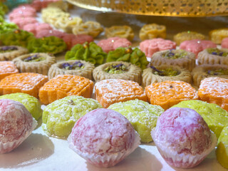 Traditional sweets cookie on holiday of henna. Arabic and Jewish sweets with nuts and sesame. Many colorful cookie on table. gold traditional utensils.