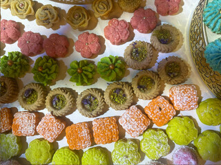 Traditional sweets cookie on holiday of henna. Arabic and Jewish sweets with nuts and sesame. Many colorful cookie on table. gold traditional utensils.