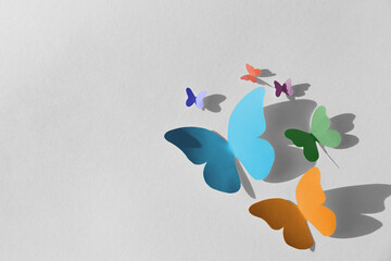 Colorful bright paper butterflies on white wall - obrazy, fototapety, plakaty