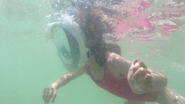  Young brave girl kid snorkeling and swimming with mask underwater view in sea