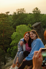 happy couple women friends taking picture on sunset