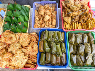 Various prepared street food on display seen in Jakarta. street food dishes displayed during the Ramadhan market on a brightly colored plastic container.