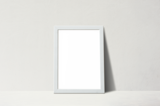 White picture frame leaning against on a beige wall