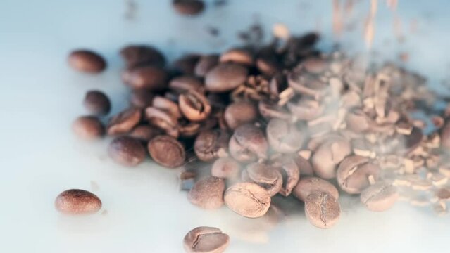 Pile of aromatic falling coffee beans  in hot steam close-up background. Aroma of organic coffee seeds.