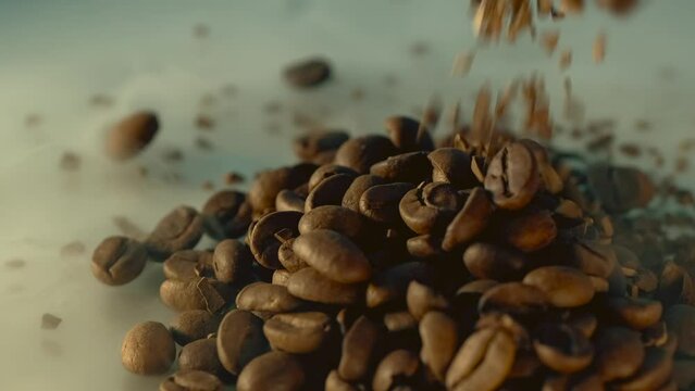 Grinding roasted coffee beans in aromatic smoke falling in heap close up, background. Preparation fresh caffeine on manufacturing. Seeds of coffee.