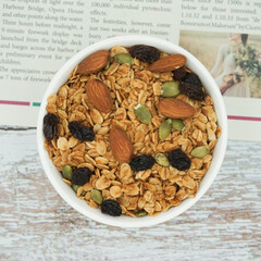 Top view of Homemade granola with mix nuts in a white bowl. Healthy snack and breakfast.
