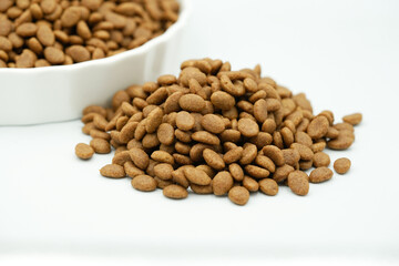 Close up of dry pet food on white background. Selective focus concept.