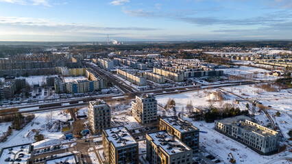 Drone photography of a few multistory house and parking lot covered by snow during winter day