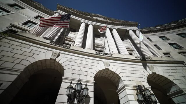 Wide angle view looking straight up at the flags and columns of the US Environmental Protection Agency, EPA building in Washington, DC.