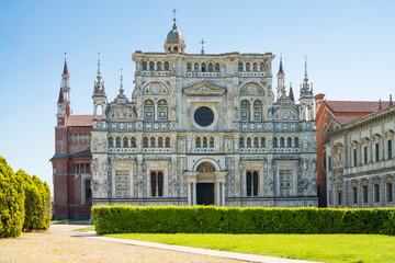 Certosa di Pavia monastery, historical monumental complex that includes a monastery and a sanctuary. green court and a church.The Ducale Palace on the right,Pavia,Italy. - obrazy, fototapety, plakaty