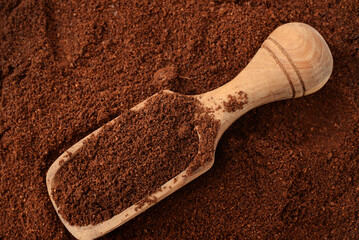 Ground coffee and wooden scoop