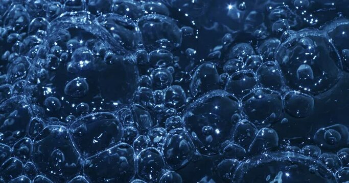 Slow motion macro of floating micro particles molecules in liquid are analyzed with microscope by chemist during innovative new medical research and analysis in scientific pharmaceutical laboratory.