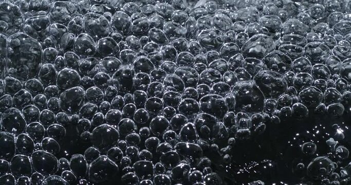 Slow motion macro of floating micro particles molecules in liquid are analyzed with microscope by chemist during innovative new medical research and analysis in scientific pharmaceutical laboratory.