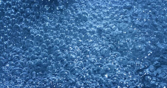 Slow motion macro of floating micro particles molecules in liquid are analyzed with microscope by chemist during innovative new medical research and analysis in scientific pharmaceutical laboratory.