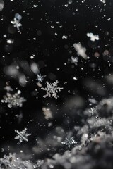 Snow flakes falling on a dark backdrop, perfect for winter themes