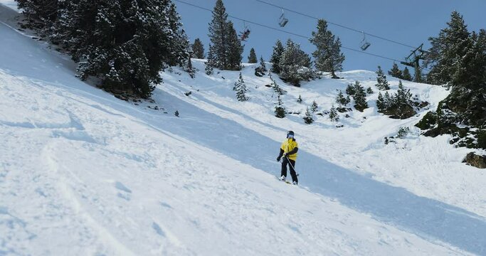 Freeride skier descending a mountain spraying powder snow in a ski resort