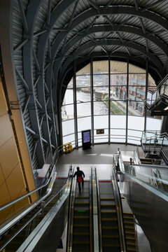 Leeds railway station, interior of domed gold south entrance with escalators and view out to the River Aire flowing outside, Leeds, UK 04 11 2024