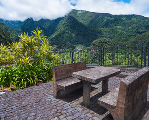 concrete bench and table with beautiful view on green hills and valley from resting place, viewpoint at Sao Roque do Faial Santana , Madeira Island, north coast.