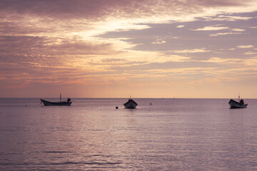 Obraz premium Fishing boats at sunset off the coast of Koh Phangan