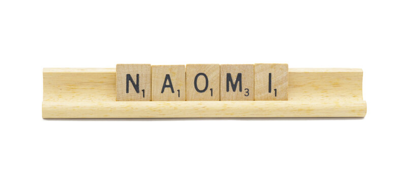 Miami, FL 4-18-24 popular baby girl first name of NAOMI made with square wooden tile English alphabet letters with natural color and grain on a wood rack holder isolated on white background