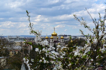 view of the domes of the Spassky Cathedral in Pyatigorsk, Russia,  from Mount Mashuk through flowering trees in early spring