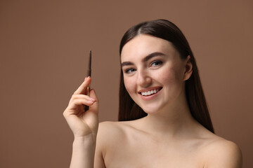 Obraz premium Happy woman with freckle pen on brown background. Space for text