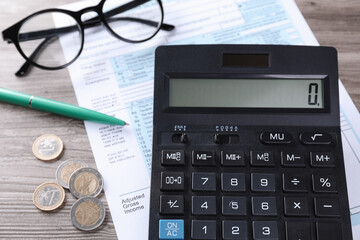 Tax accounting. Calculator, document, pen and coins on wooden table, closeup