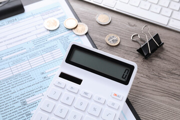 Tax accounting. Calculator, document, coins, keyboard and binder clip on wooden table, closeup