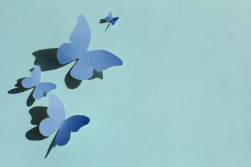 Bright blue paper butterflies on cyan background